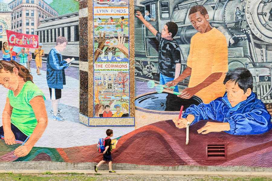 little boy in front of mural