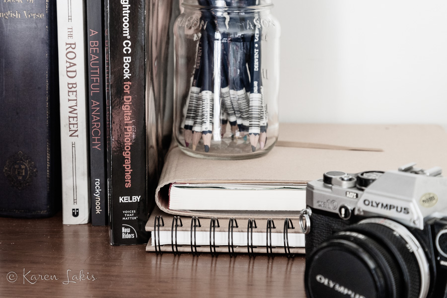 view of dresser with books and old camera